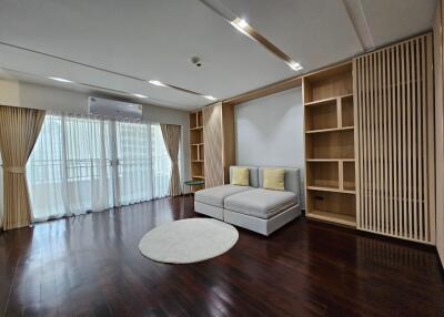 Spacious living room with large windows and wooden floor