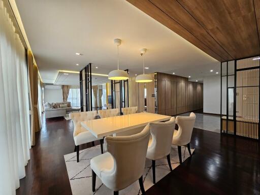 Modern dining area with white chairs and a large table