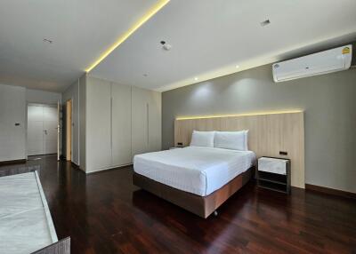 Modern bedroom with wooden floor and ambient lighting