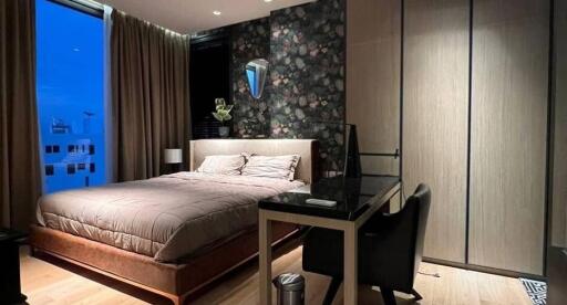 Modern bedroom with large windows, double bed, and wardrobe