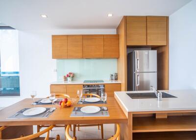Modern kitchen with wooden cabinetry and dining area