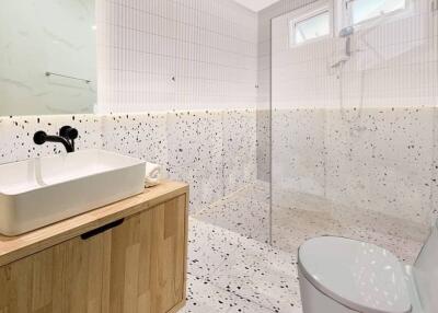 Modern bathroom with terrazzo tiles and a glass shower