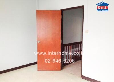 Empty bedroom with an open wooden door
