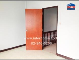 Empty bedroom with an open wooden door