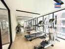 Modern gym with exercise equipment and large windows