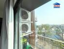 Balcony view with two air conditioning units and distant cityscape