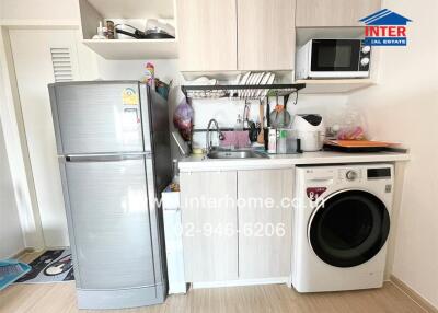 Small kitchen with refrigerator, washing machine, microwave, and sink