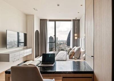 Modern bedroom with city view, featuring desk work area and mounted TV