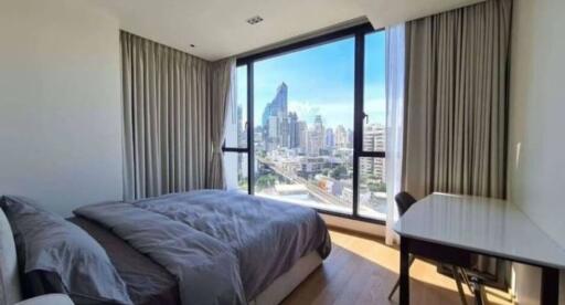 Bedroom with a large window offering a city view