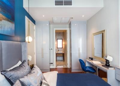 Modern bedroom with blue accents and ensuite bathroom