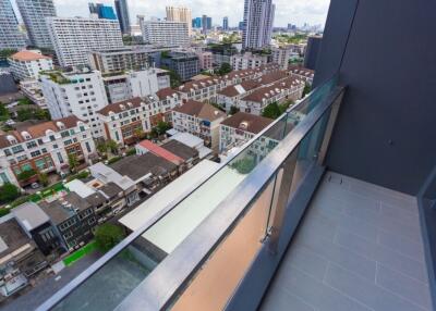 High-rise balcony with glass railing overlooking cityscape