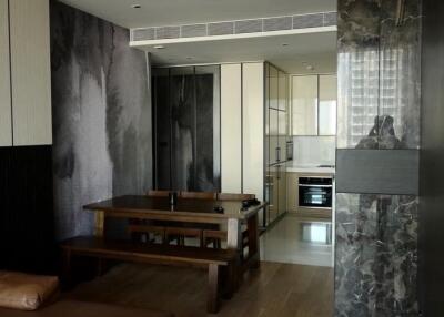 Modern dining area with wooden table adjacent to sleek kitchen