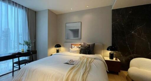 Modern bedroom with a large window, double bed, nightstands, desk, and chair