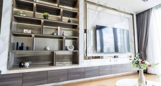 Modern living room with built-in shelving and large TV