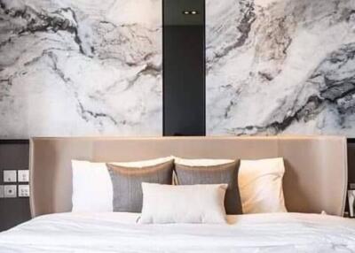 Elegant bedroom with a king-sized bed and marble accent wall