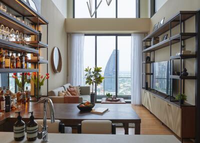 Modern living room with a kitchen and floor-to-ceiling windows