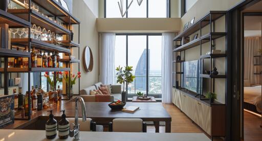 Modern living room with a kitchen and floor-to-ceiling windows