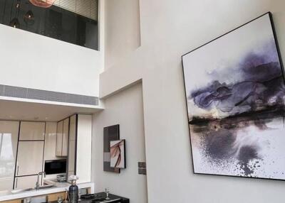 Modern living area with high ceiling and artwork