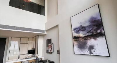 Modern living area with high ceiling and artwork