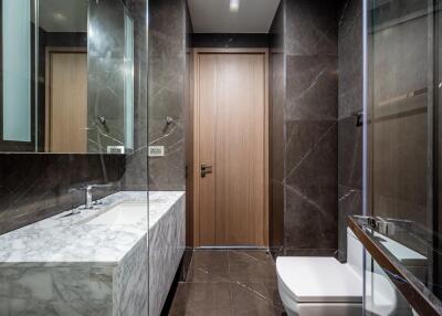 Modern bathroom with marble sink and dark tile walls