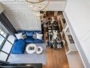 Aerial view of living and dining area with blue sofa and dining table with chairs