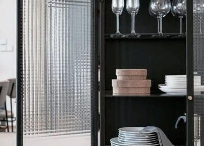 Dining area showcasing a glass cabinet with dinnerware and wine glasses