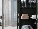 Dining area showcasing a glass cabinet with dinnerware and wine glasses