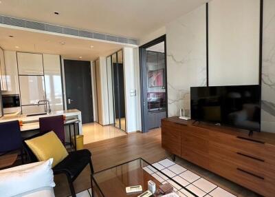 Modern living room with television and a view into a kitchen area