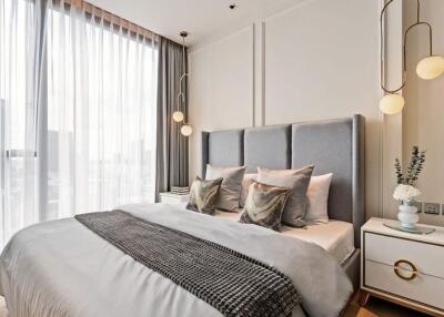 Modern bedroom with large windows, a gray upholstered bed, and stylish lighting fixtures