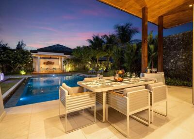 Elegant outdoor dining area with pool at sunset