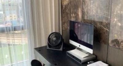 Home office setup with a computer and fan