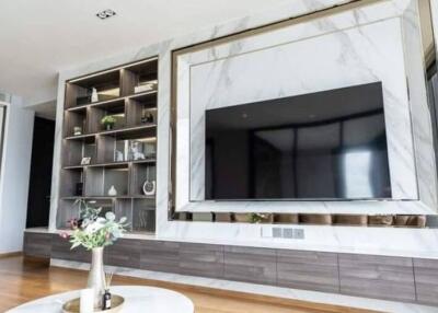 Modern living room with built-in shelving and large flat-screen TV