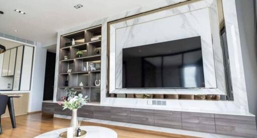 Modern living room with built-in shelving and large flat-screen TV