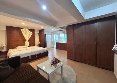 Spacious bedroom with bed, wardrobe, and seating area