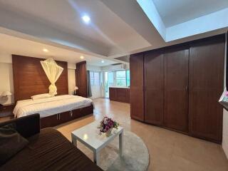 Spacious bedroom with bed, wardrobe, and seating area