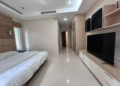 modern bedroom with large bed and dual flat-screen TVs