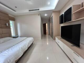 modern bedroom with large bed and dual flat-screen TVs