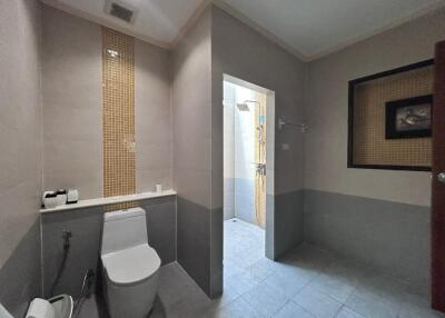 Modern bathroom with toilet, shower area, and tiled floor