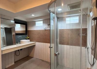 Modern bathroom with a glass shower enclosure, vanity area, and overhead lighting
