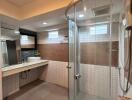 Modern bathroom with a glass shower enclosure, vanity area, and overhead lighting