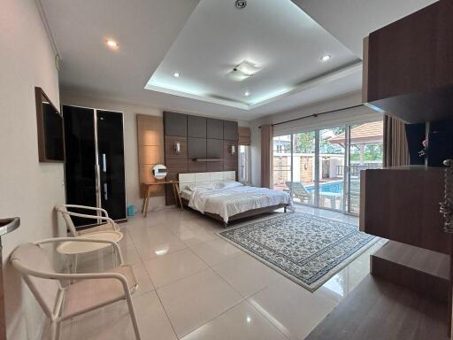 Spacious bedroom with modern furnishings and large windows