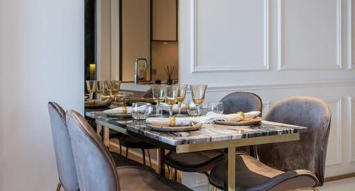 Elegant dining room with a marble table and grey velvet chairs