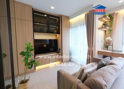 Modern living room with built-in cabinets, large window, sofa, and interior decorations.