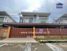 Modern two-story house with driveway and gated entrance