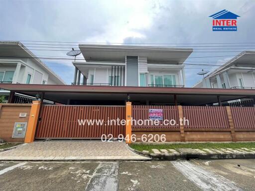 Modern two-story house with driveway and gated entrance