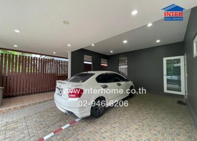 Covered garage space with tiled flooring and a white car