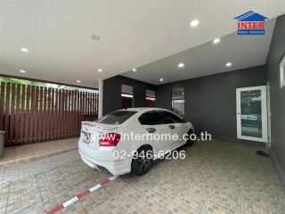 Covered garage space with tiled flooring and a white car