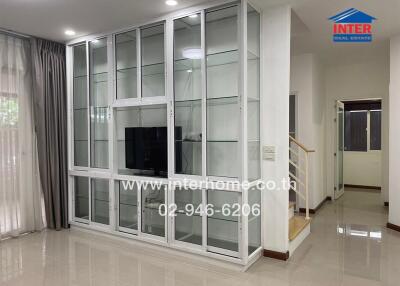 Spacious Living Room with Glass Cabinet and Television