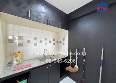 Small kitchen with dark cabinets and white-tiled backsplash