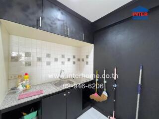 Small kitchen with dark cabinets and white-tiled backsplash